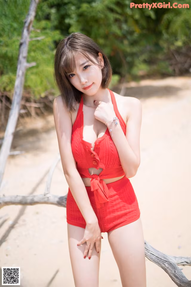 A woman in a red bathing suit posing for a picture.