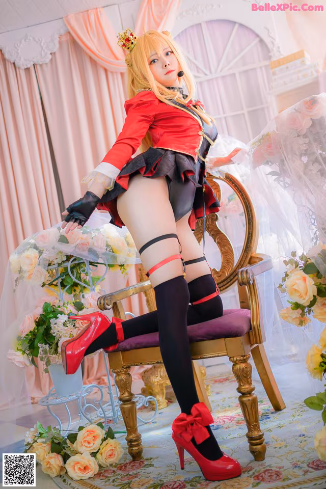A woman in a red and black outfit sitting on a chair.