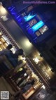 A group of people standing outside of a restaurant at night.