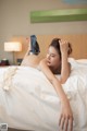 A woman laying on top of a bed in a bedroom.