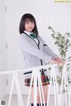 A young woman in a school uniform posing for a picture.