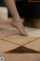 A person standing on a tic tac toe game on the floor.