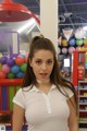 A woman standing in front of a store filled with lots of candy.