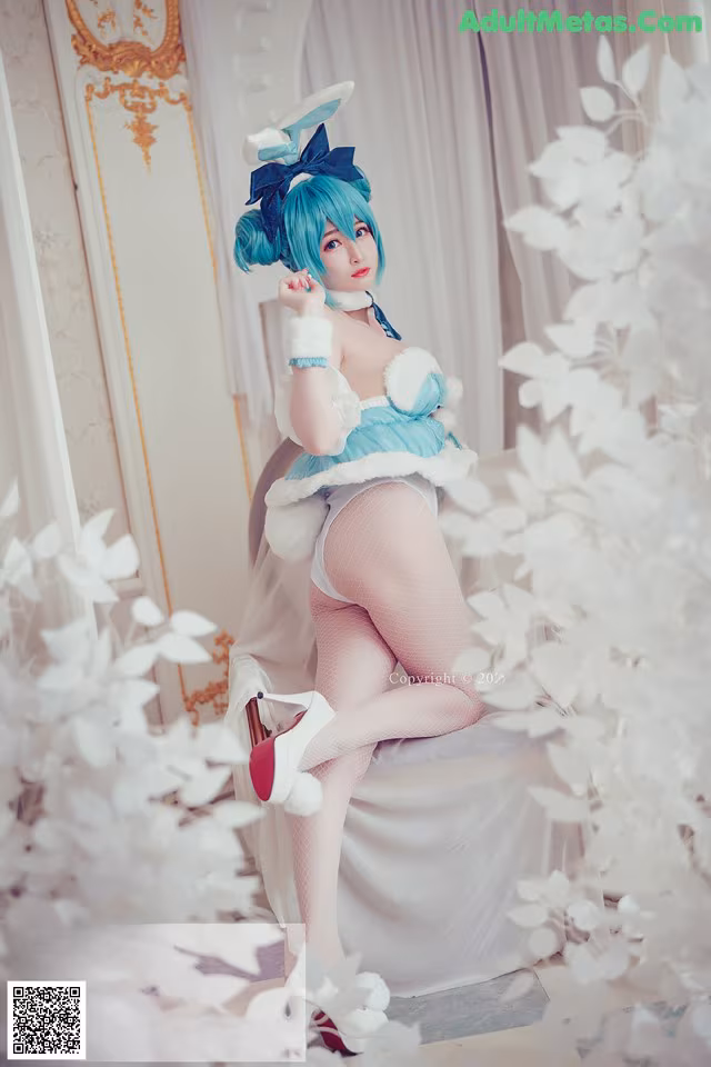 A woman in a blue and white outfit sitting on a chair.