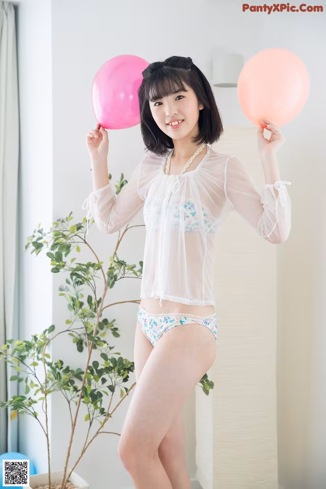 A woman in a white shirt and panties holding pink balloons.