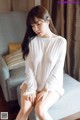 a woman sitting on top of a couch next to a window