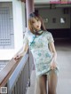 A woman in a blue and white dress posing on a balcony.