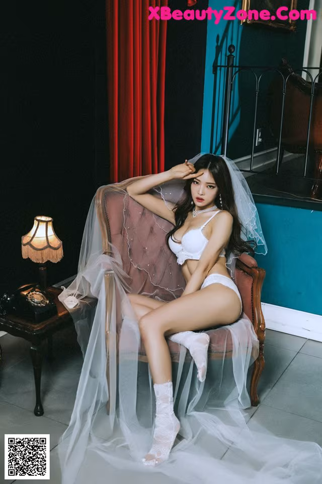 A woman sitting on a chair wearing a white lingerie.